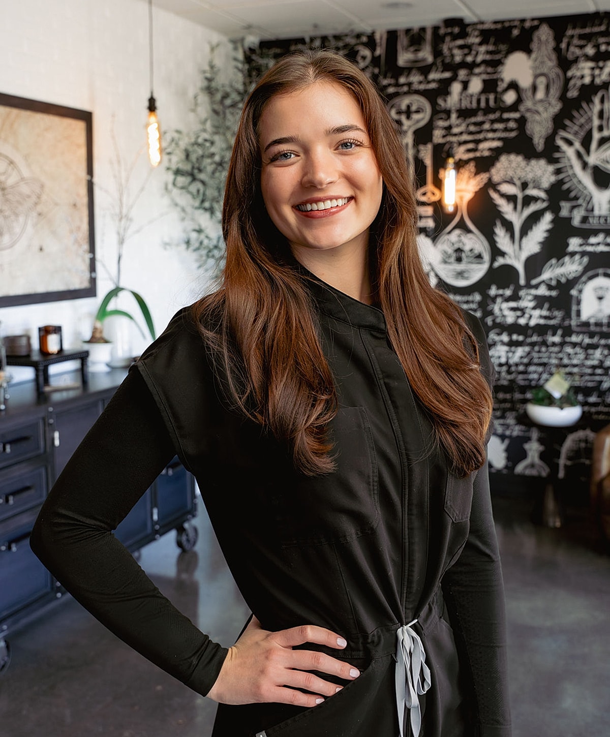 Smiling woman in a stylish black outfit.