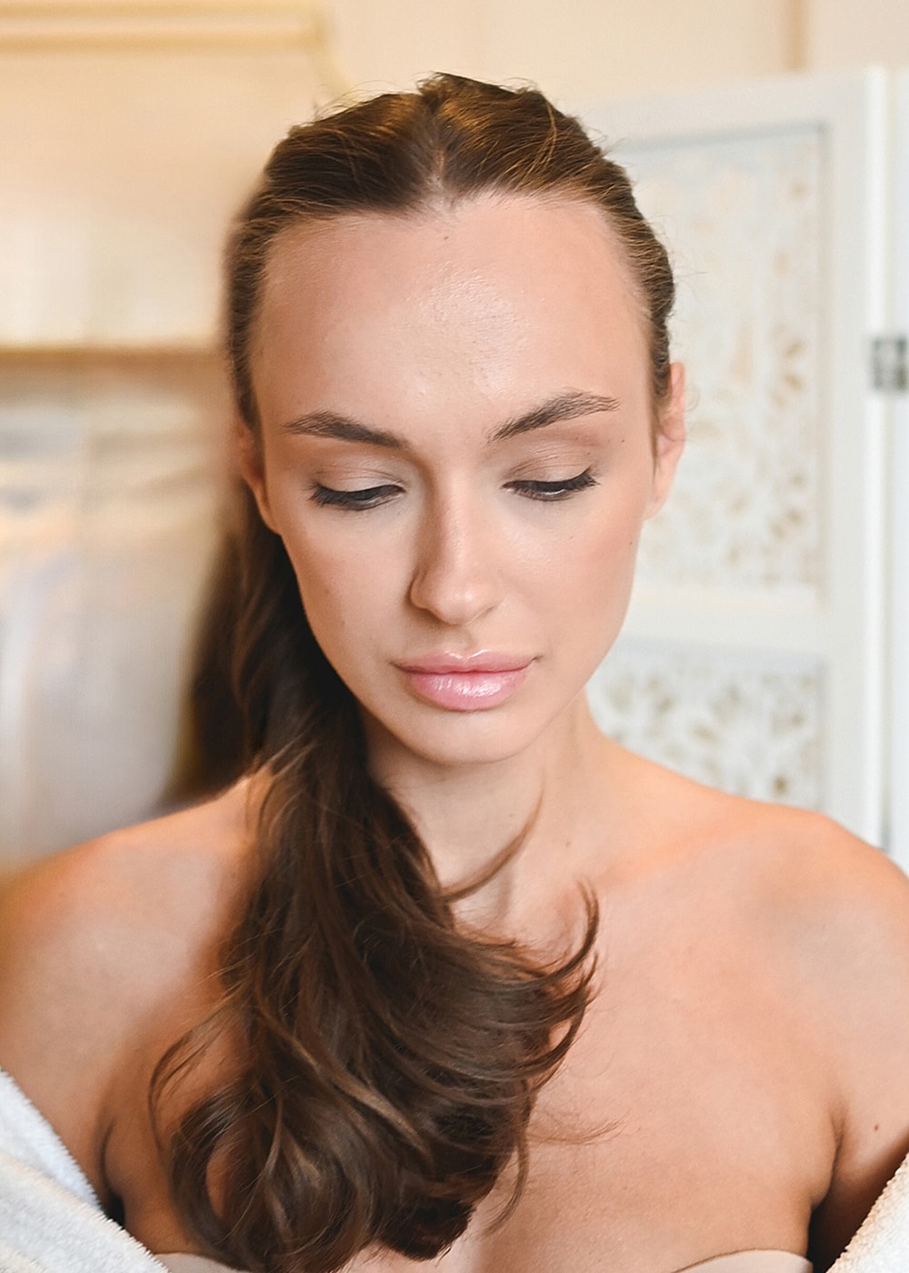 Woman with long hair in softly lit setting.