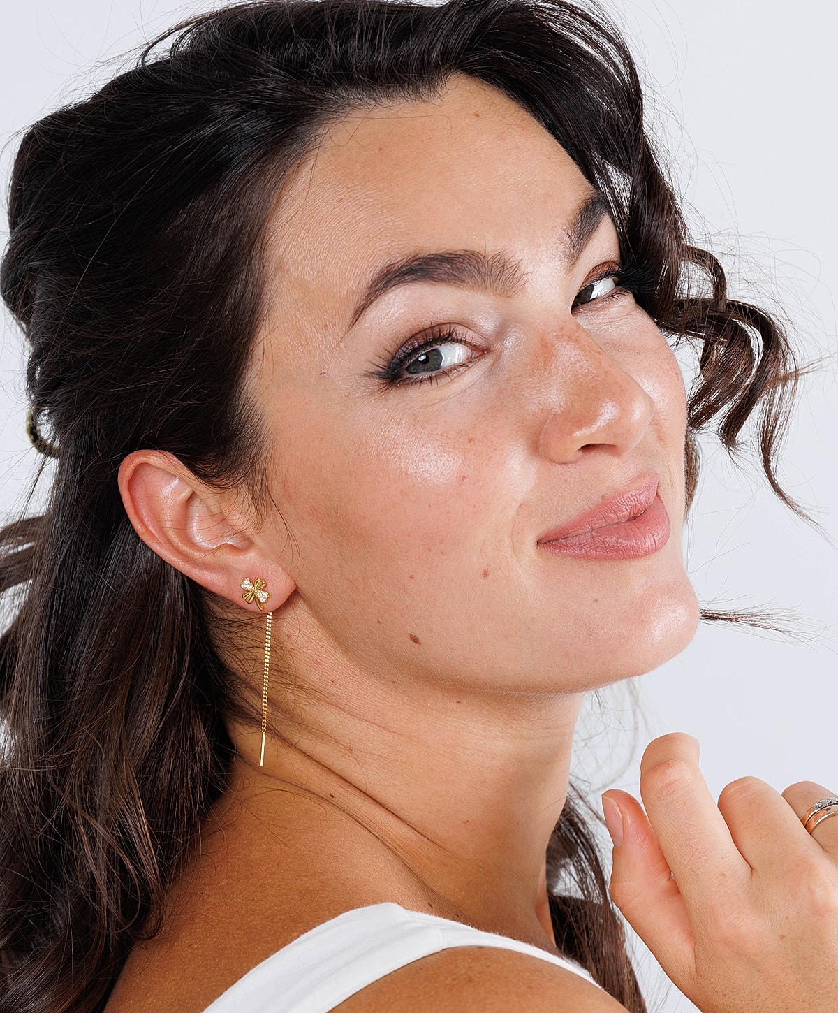 Woman smiling with curly hair and earrings.