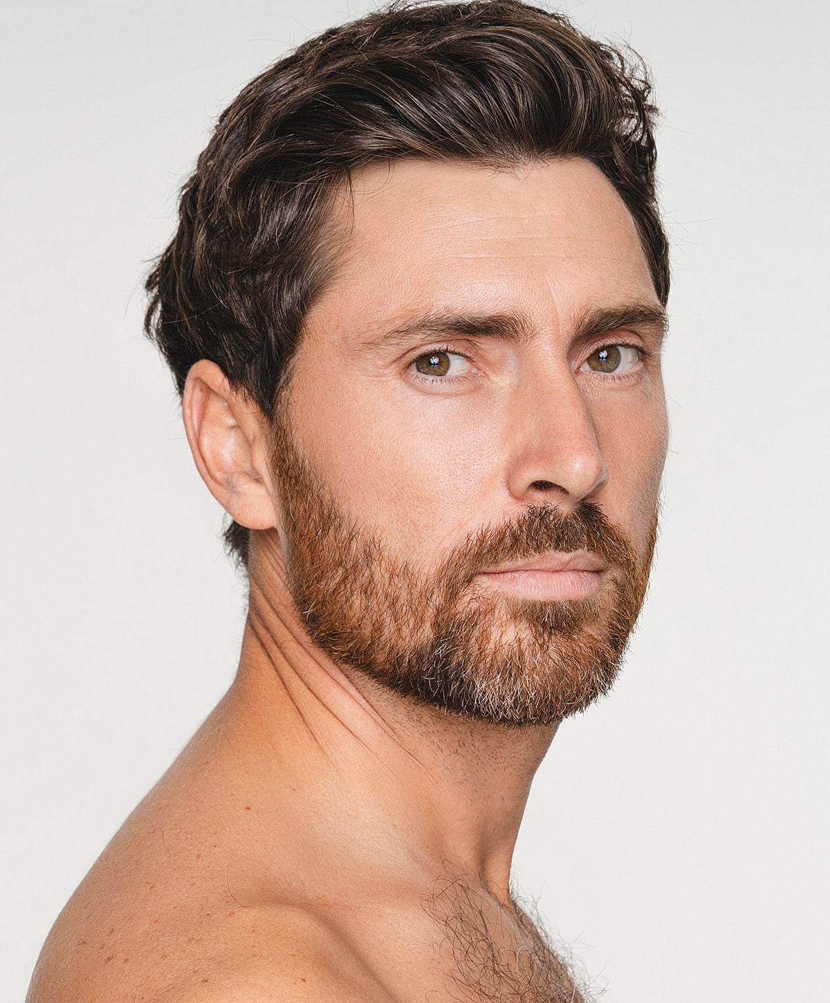 Man with beard and tousled hair, side profile.
