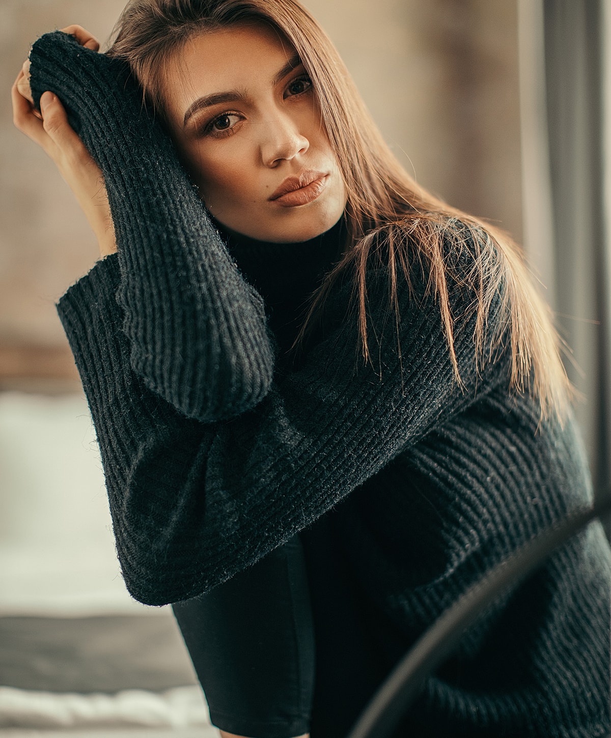 Woman in black sweater with thoughtful expression.