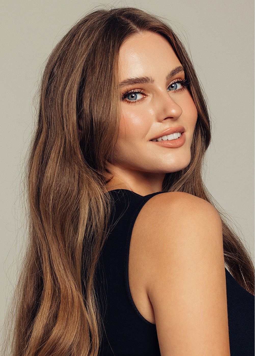 Smiling woman with long, wavy brown hair.