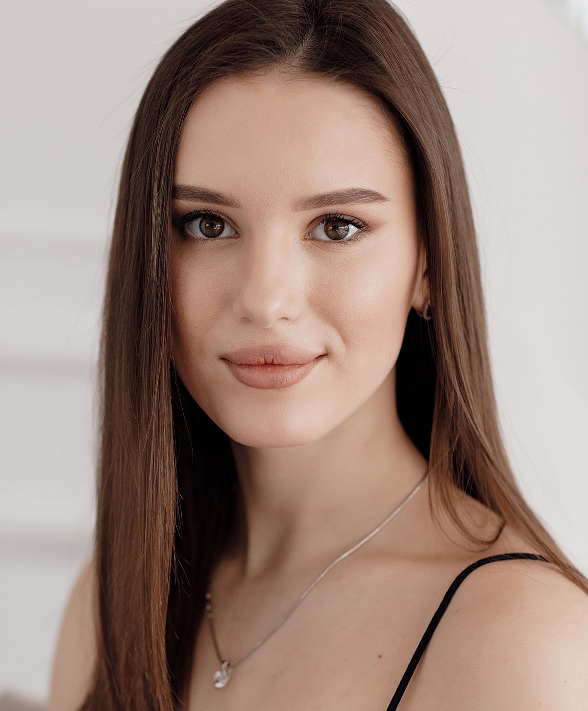Young woman with long hair and subtle makeup.
