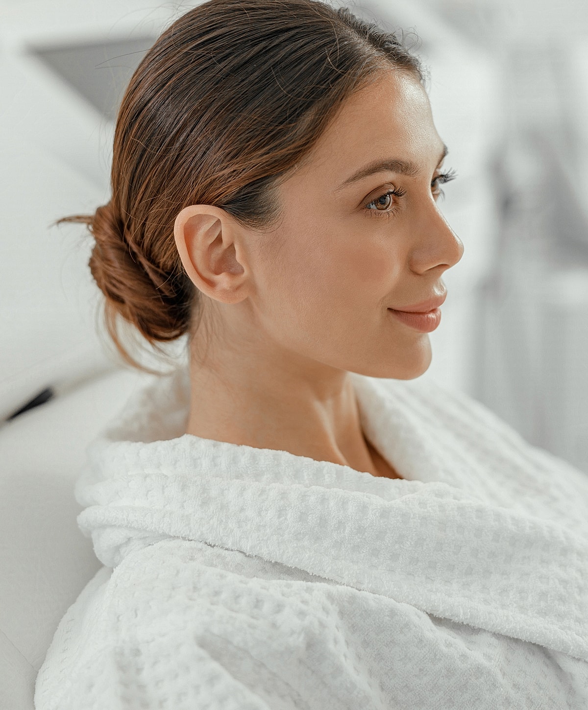 Woman in white robe, relaxing, profile view.
