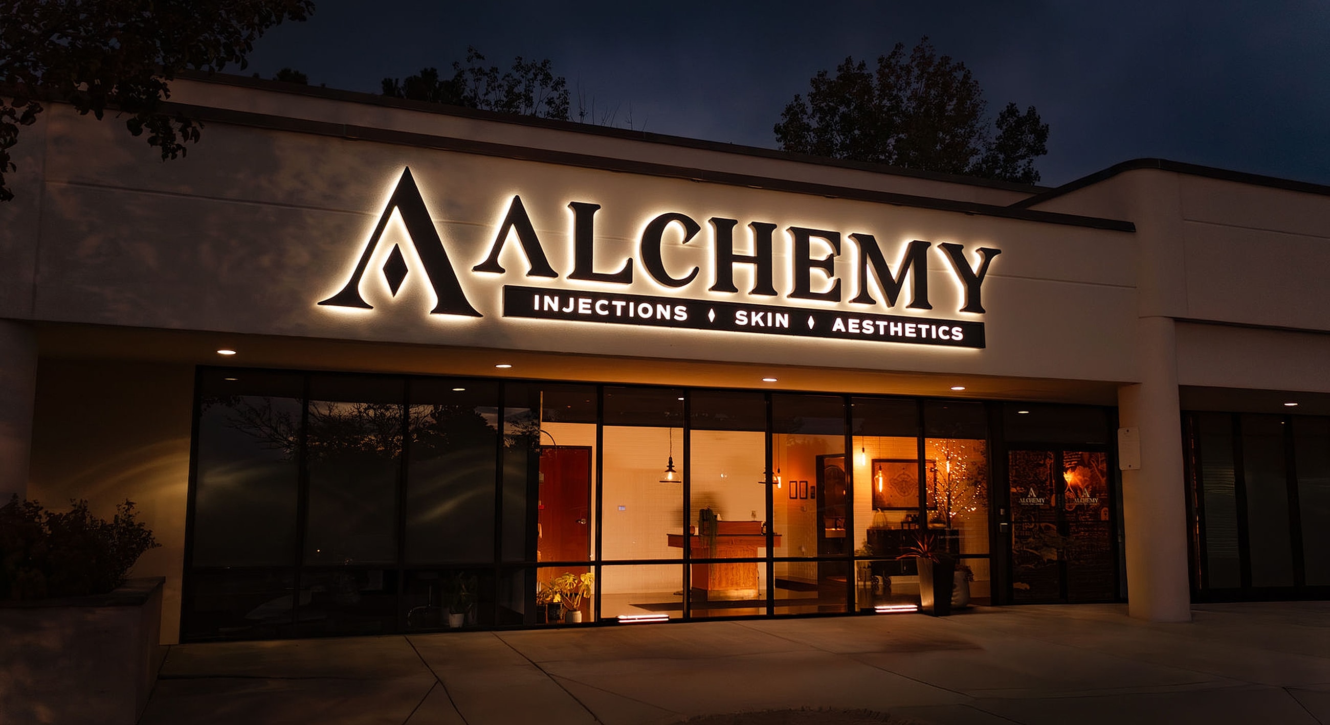 Alchemy aesthetics clinic exterior signage at night.