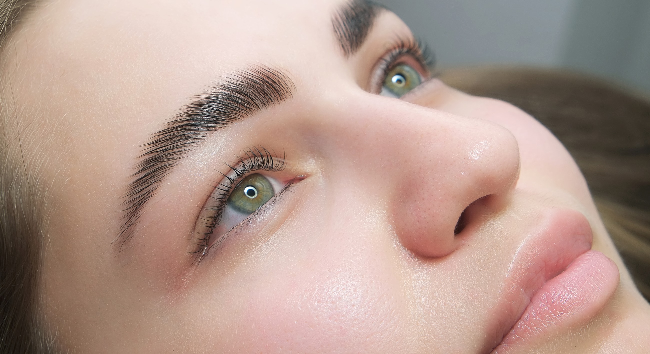 Close-up of a person with striking green eyes.