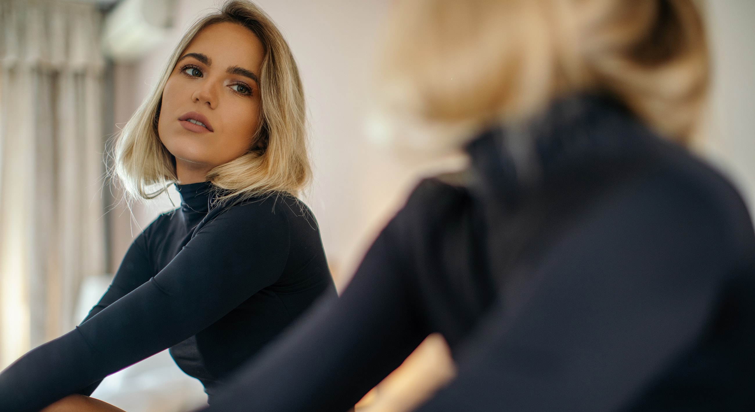 Woman in black outfit with soft lighting.