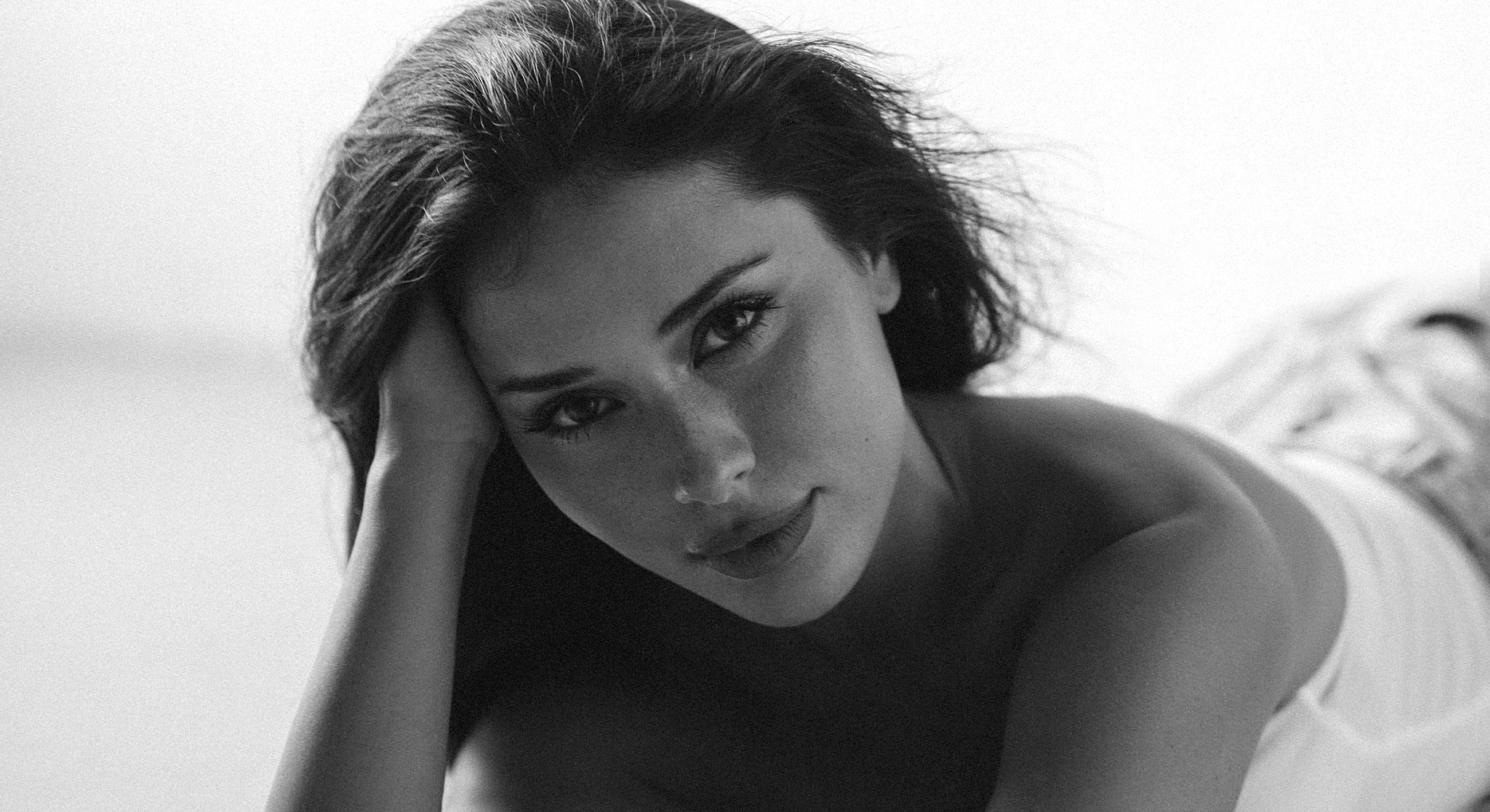 Young woman posing thoughtfully in black and white.