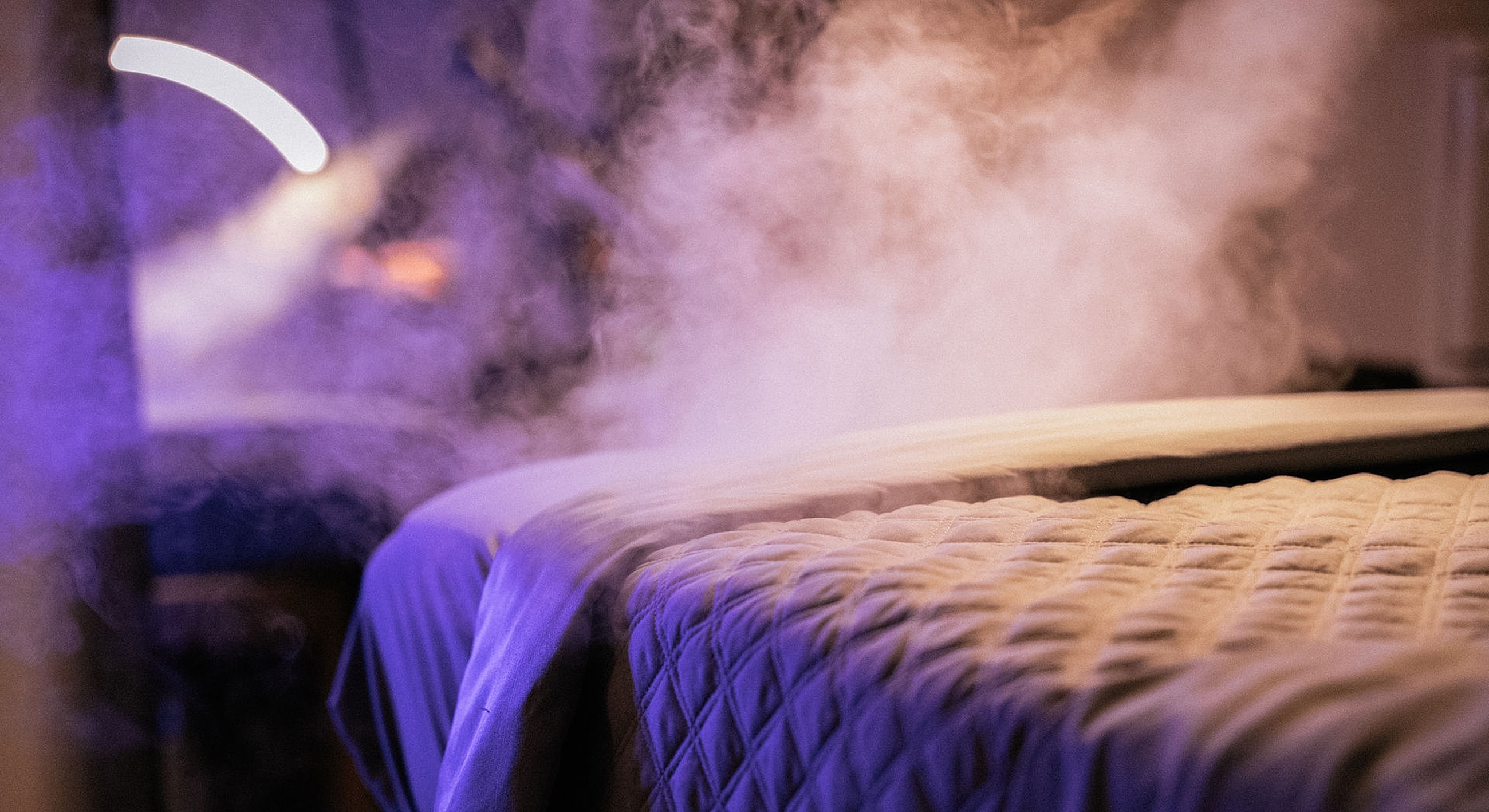 Steam rising from a bed in soft lighting.