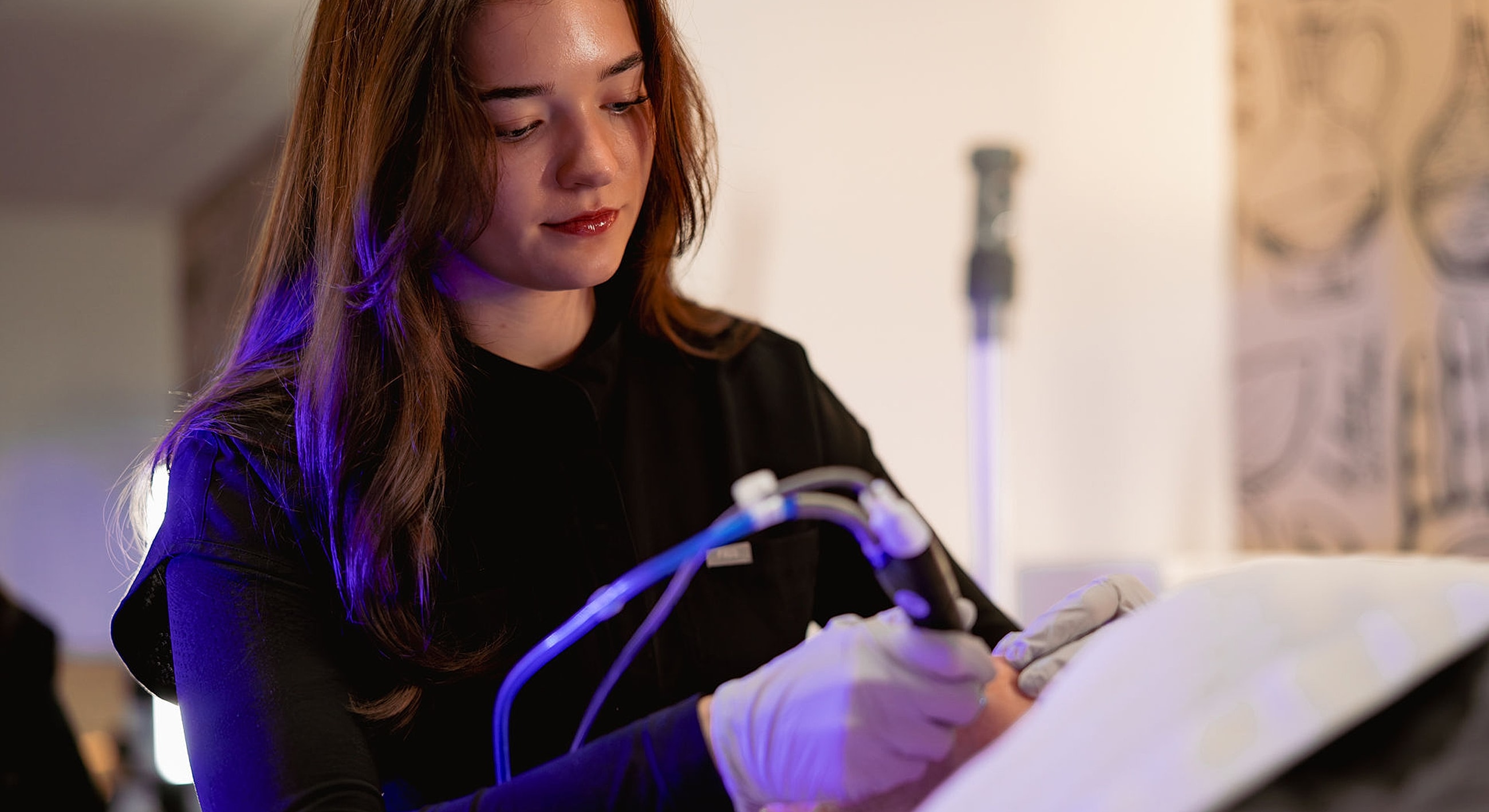 Woman performing aesthetic treatment in a studio.