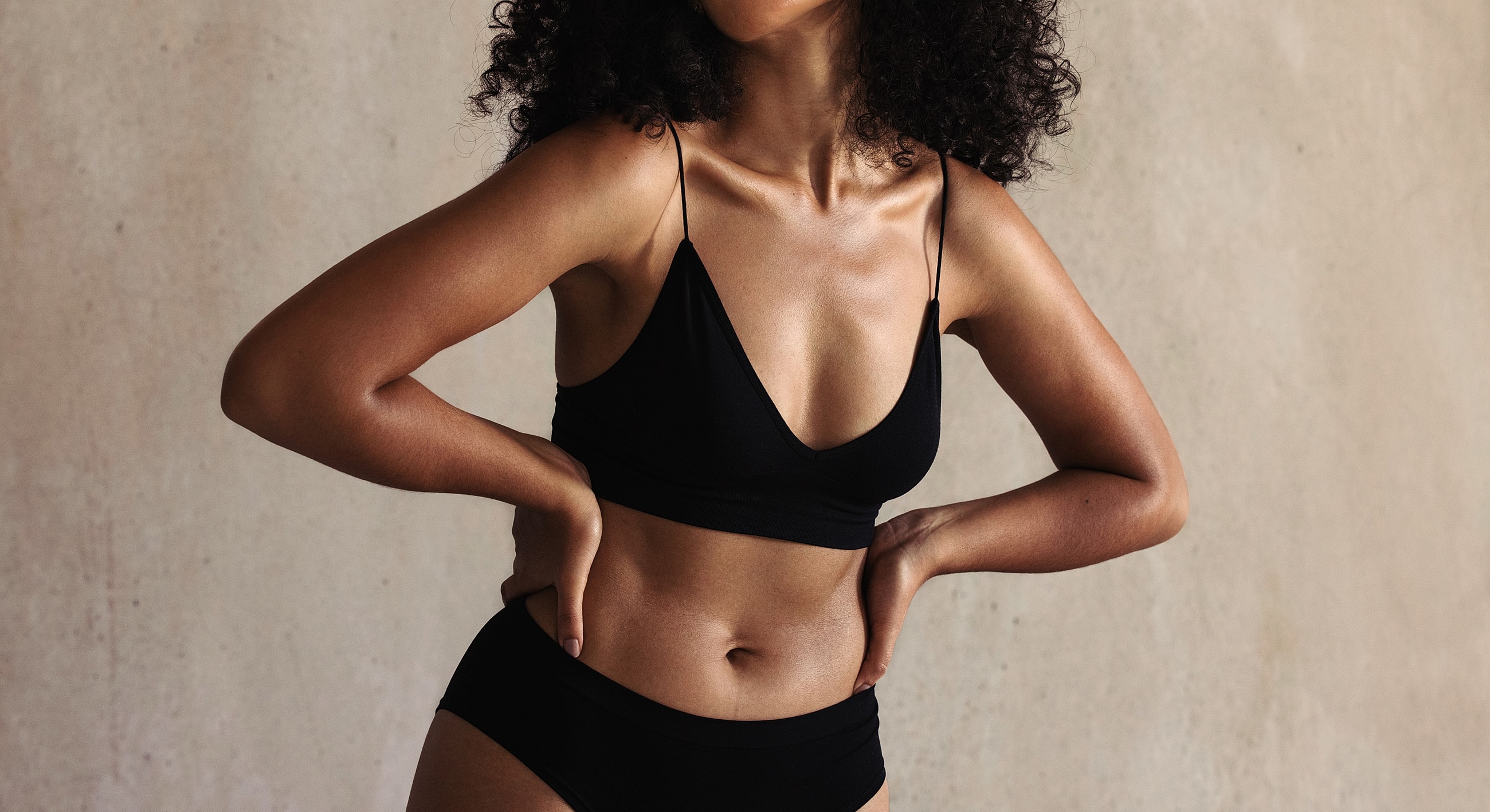Woman in black lingerie posing confidently.